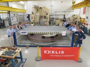 Exelis optics employees pose with &quot;a big glass paperweight&quot; that will become the secondary mirror for the Large Synoptic Survey Telescope.