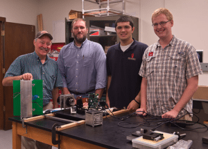 Students and teachers part of the Auburn University Small Satellite Program pose with a cubesat