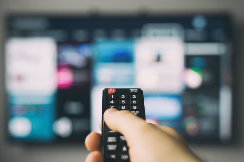 Person holding TV remote control. Photo: Sat>IP