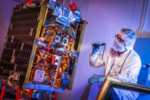 An aerospace engineering performing final checks before the GPIM satellite was shipped to Florida. Photo: Ball Aerospace