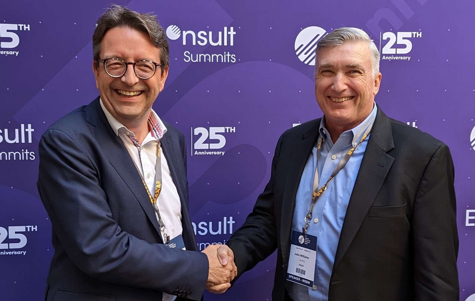 Satellite Vu CEO Anthony Baker, left, shakes hands with John Williams, vice president of Viasat's Real-Time Earth. 